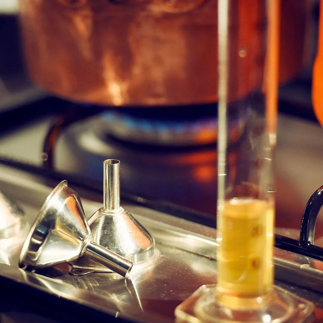 Liquore versato con un imbuto nella bottiglia nel laboratorio Alma De Lux